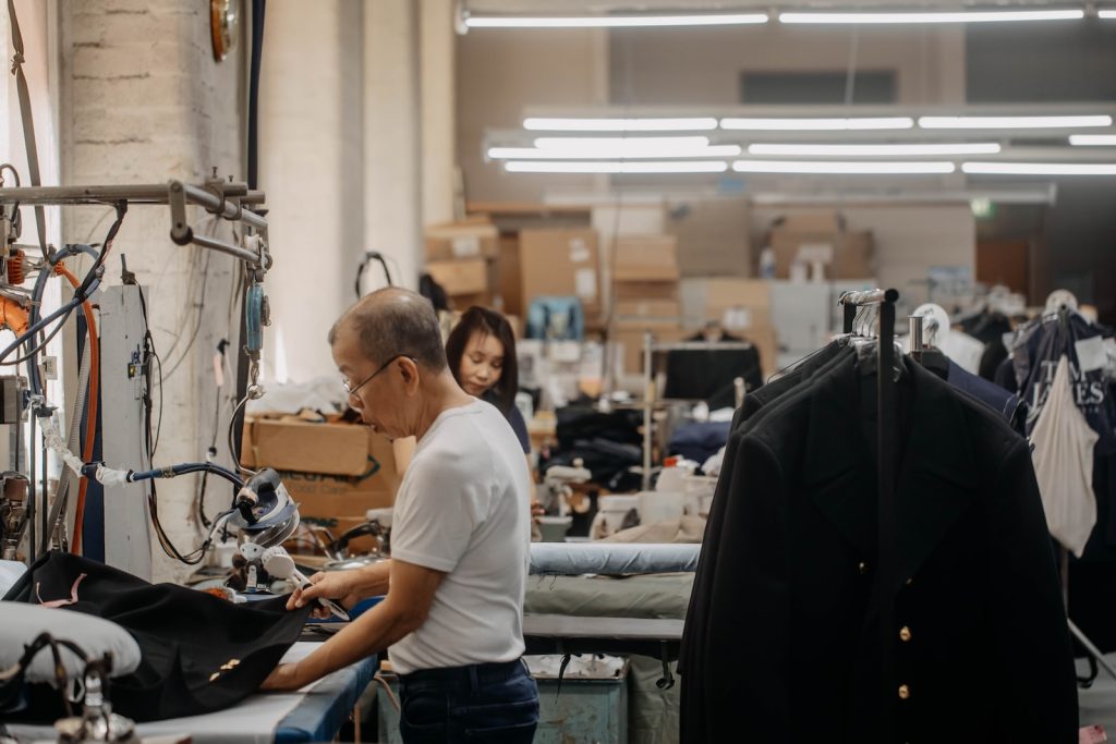 a man working on a piece of clothing in a factory